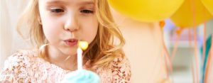 Little girl blowing out candle in cupcake for birthday, call a top rated St. Charles family law attorney for help with your child support case.