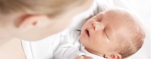 A newborn baby held by a woman, call a top rated Oak Park family law attorney for help with your child support case.