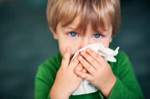 Small boy blowing nose with tissue, contact the Oak Brook family law lawyers for help with your child support case.