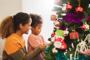 A mother and daughter decorate a Christmas tree representing how an Elmhurst family law lawyer an help you.