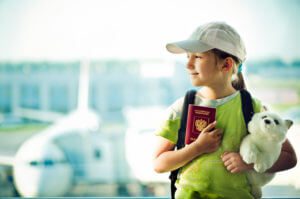 Little girl holding passport at airport, contact the Glenview child custody lawyers for help with your parenting time case.