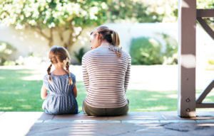 A mom and daughter sitting on front porch steps, contact the Elmhurst child custody lawyers for help with your parenting time case.