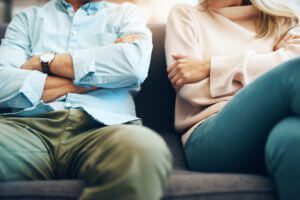 A man and woman sitting on a couch with arms folded, contact the Downers Grove child custody attorneys for help with your parenting time case.