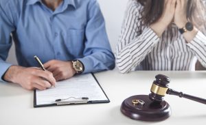 A couple signs their divorce decree after meeting with our Downers Grove divorce attorneys.