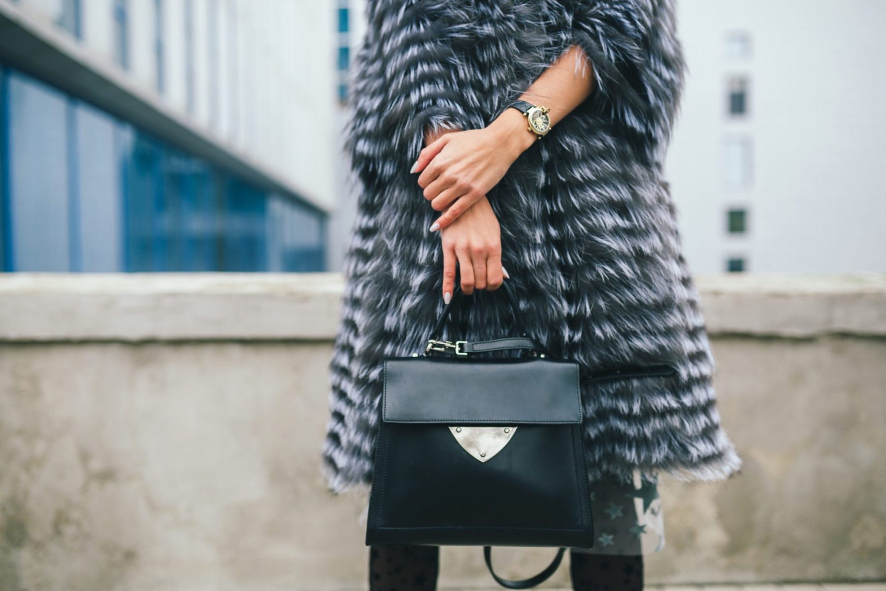A woman in a furry coat holding a designer bag, if deciding to end marriage, meet with a good Downers Grove divorce lawyer.