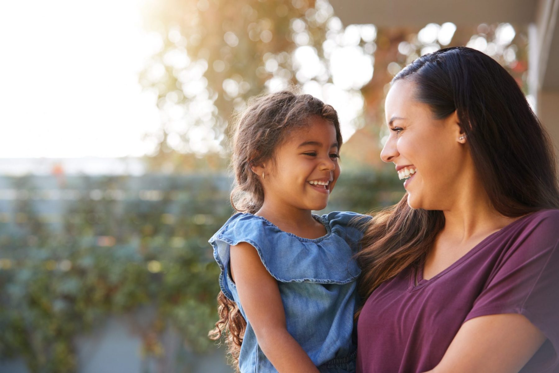 A woman holding her daughter both laughing, if deciding to end marriage, meet with a top rated Downers Grove divorce attorney.