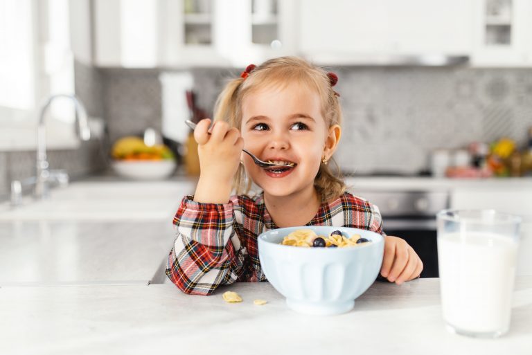 A little girl eating a bowl of fruit representing how you should call a Downers Grove child support attorney.