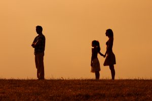 Silhouette of man standing with back to wife and child, when developing a fair custody agreement with a Parenting Plan Attorney Oak Brook.
