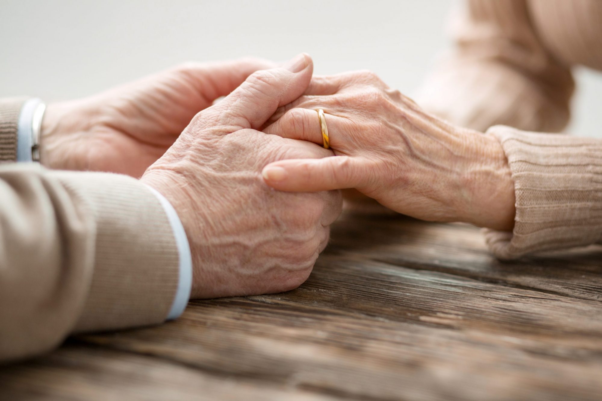 A senior married couple embracing hands, contact our gray divorce attorneys Oak Brook when needing to end marriage.