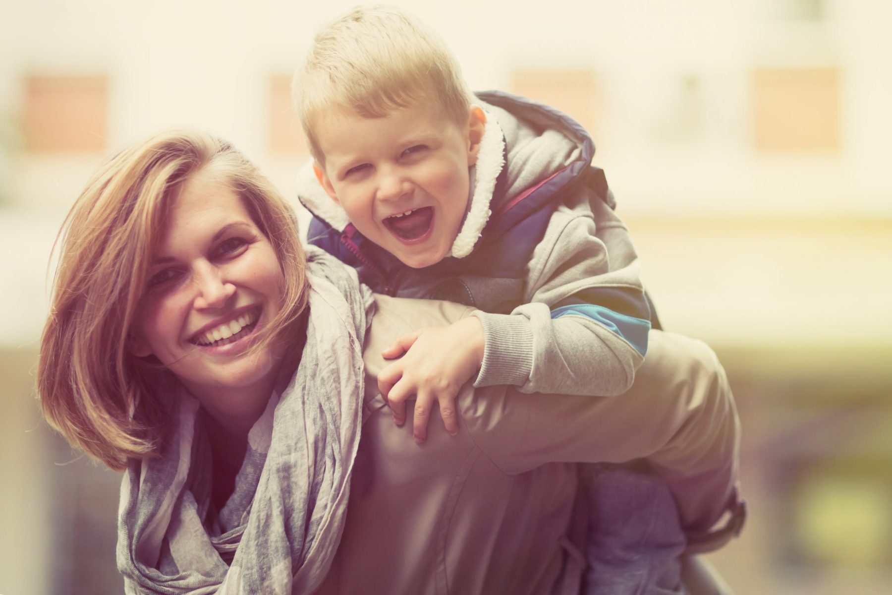 Smiling mother with son on her back, for Child Custody Lawyers Elmhurst contact our team for dependable parenting time.
