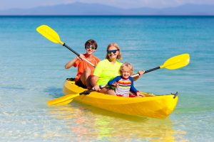 Mother with children in kayak in ocean on vacation to represent changes with Child Custody Lawyer in Chicago.
